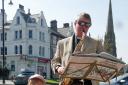 The Rev Michael Burley is pictured busking in Ilkley to raise money for the spire appeal.