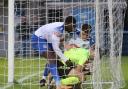 Two Guiseley players try to wrestle the ball back from the Hyde United goalkeeper on Saturday