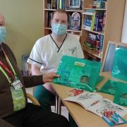 John Lofthouse, left, presents the colouring packs to occupational therapist Nathan Cox on Ward 5