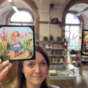Rhian Isaac, special collections librarian at Leeds Central Library, with the vintage magic lantern slides featuring moments from classic tales including Alice in Wonderland, Peter Pan and Aladdin