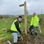 Roger Bullen and Peter McLoughlin repair the sign