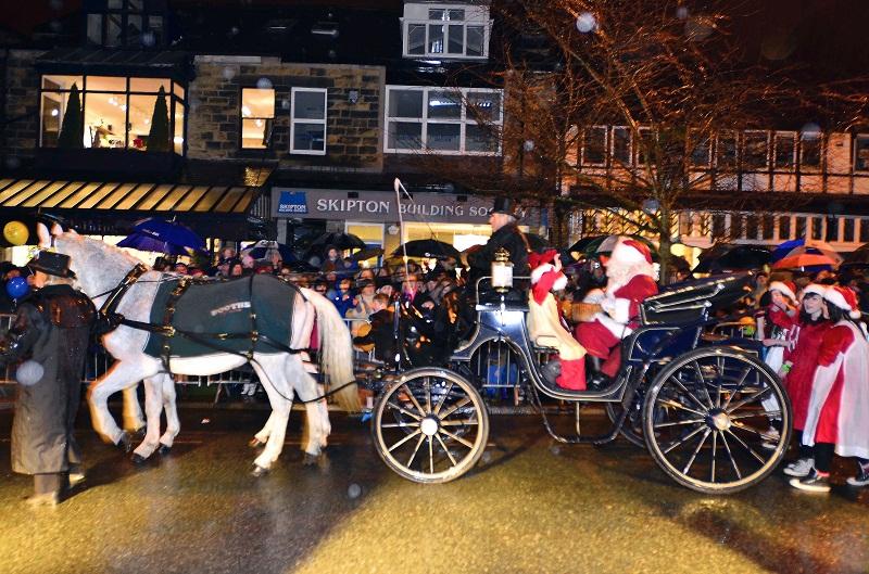 Families and children line the route as Santa's horse-drawn carriage arrives