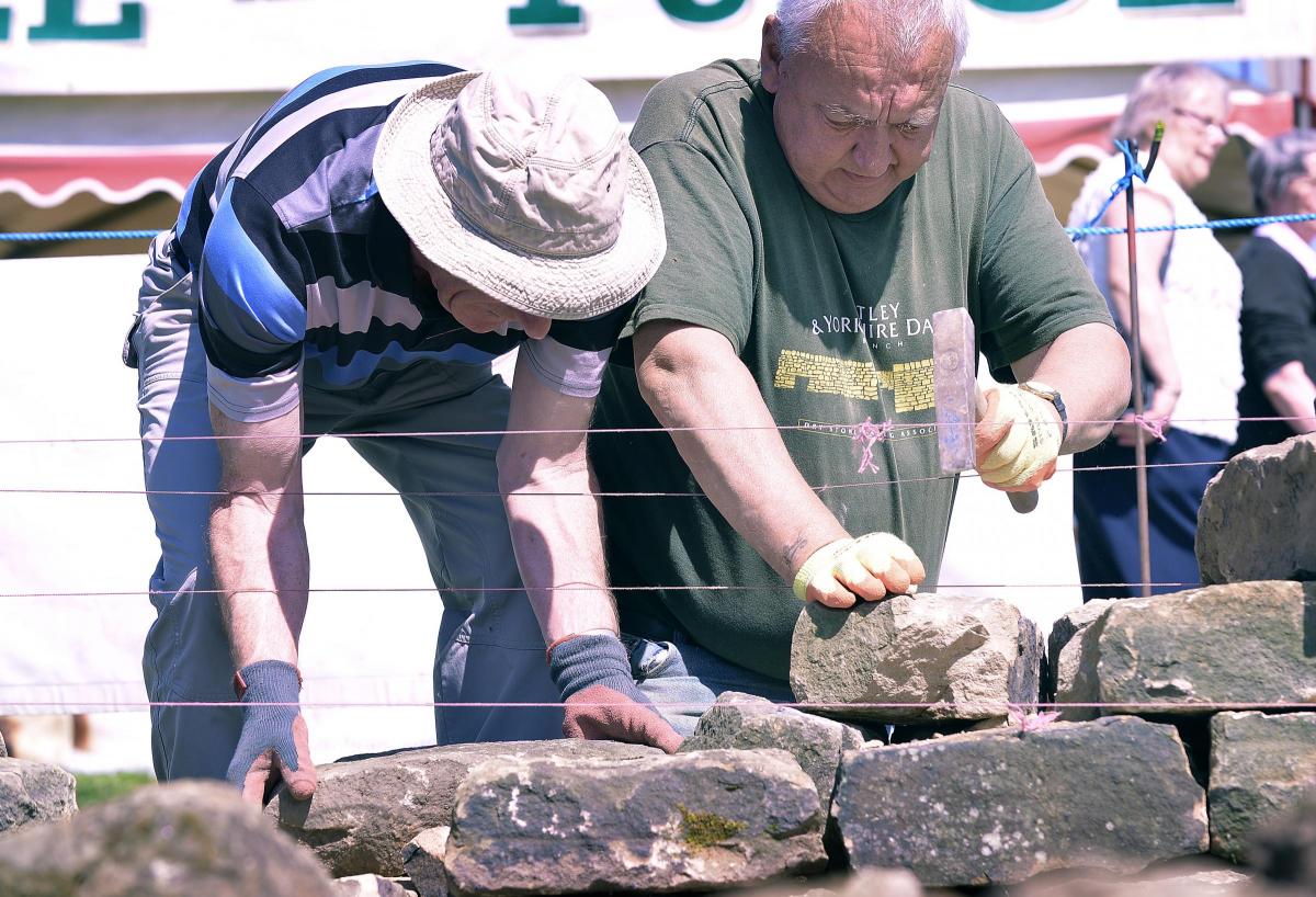 Demonstrating the art and skill required to build a real dry stone wall are David Hicks and Keith Sturdy. 