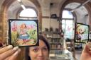Rhian Isaac, special collections librarian at Leeds Central Library, with the vintage magic lantern slides featuring moments from classic tales including Alice in Wonderland, Peter Pan and Aladdin