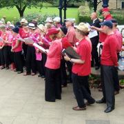 The Moornotes community choir perform On Ilkla Moor Baht ’At at the bandstand on The Grove.