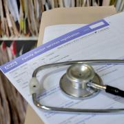 A stethoscope and a GP registration form