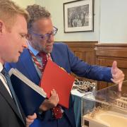 MP Robbie Moore, left, looks at the design for the hospital