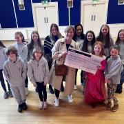 Members of the junior chorus, adult cast and Jo Onions from Reset Counselling collecting a cheque on behalf of Reset and Sue Ryder Manorlands